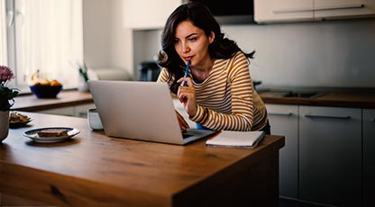Image of a women using her laptop in a kitchen