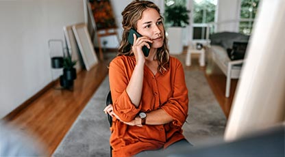 Image of person at a table talking on phone