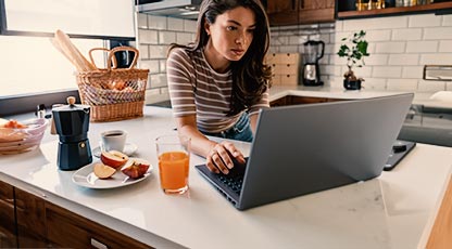 Person sitting at table looking at laptop
