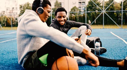 Image of two people sitting in park, smiling, and talking