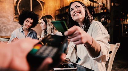 Person smiling and handing their debit card to someone else