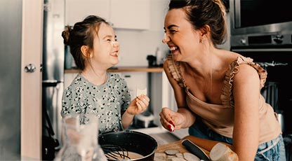Adult an child playing, and laughing in kitchen
