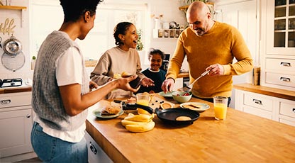 Family in kitchen making meal