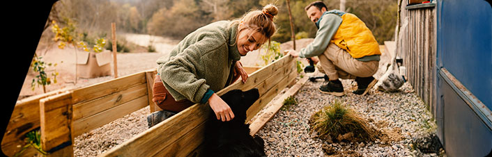 A man and a woman building a wooden structure together