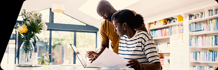 Image of a man and women looking at papers and a laptop together