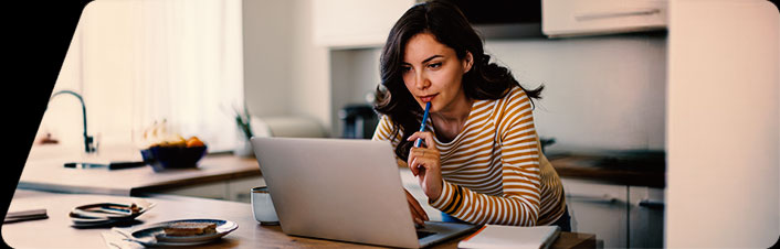 Image of a women using her laptop in a kitchen