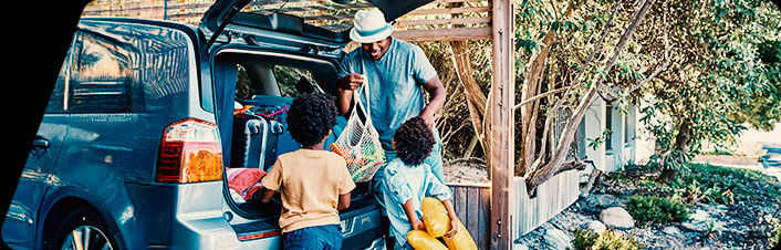 Image of parent and children packing a car