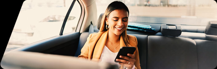 Image of woman sitting in car looking at her phone