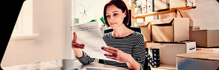 Image of a woman looking at papers sitting at a table