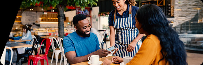 Image of two people paying for food at a coffee shop