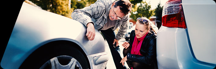 Image of two people looking at their cars after an accident