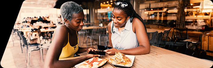 Two women using their phones to Zelle®