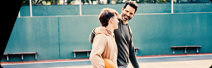 Image of parent and child walking together on basketball court