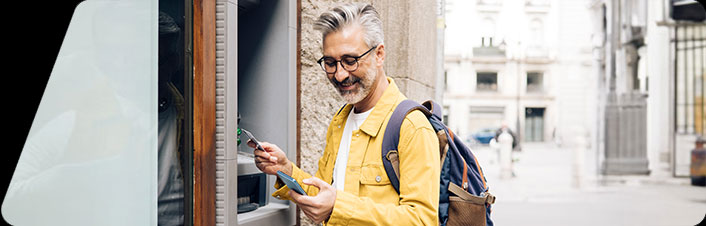 A person traveling and using an ATM machine