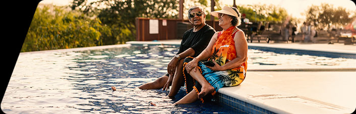 Image of people sitting on the edge of a pool.