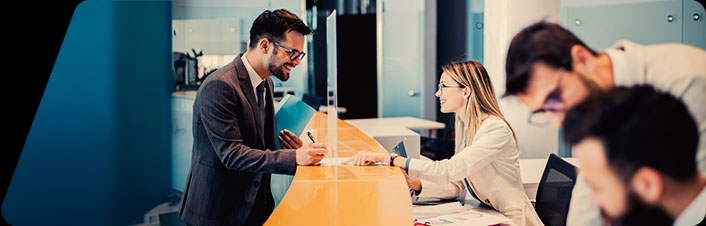 Image of a bank employee helping someone at a branch 