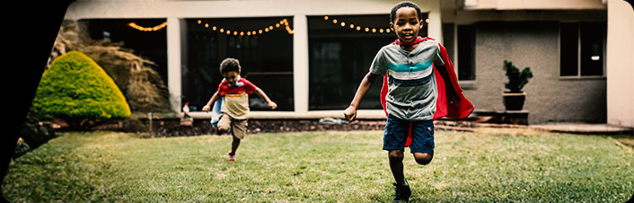 Two young children running in yard