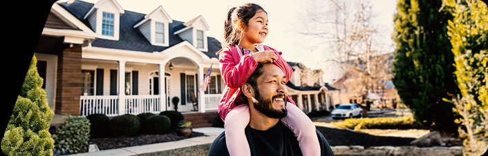 Child sitting on parents shoulders smiling