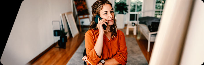 Image of person at desk with phone to ear