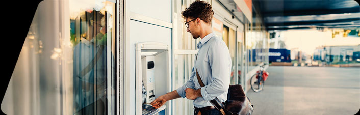 Image of a man using debit card at ATM